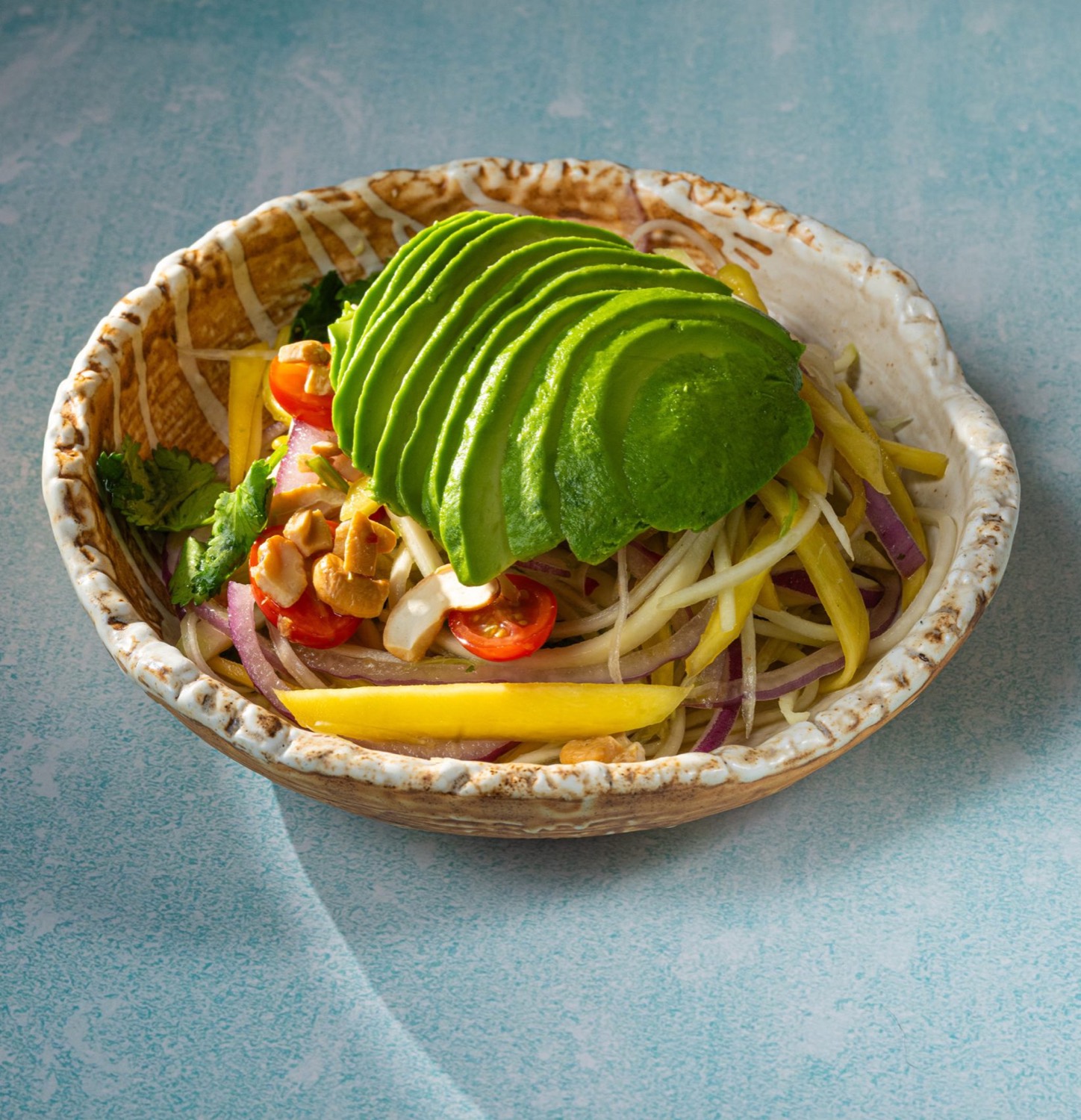 A seafood-forward Thai dish plated in a warm, moody setting